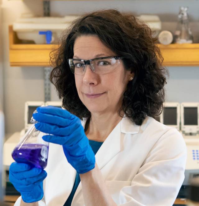 Bonnie Bassler holds up a test tube