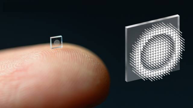 a tiny camera perched on a fingertip alonside an enlarged illustration